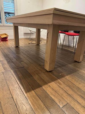 a wooden table in the middle of a hardwood floor