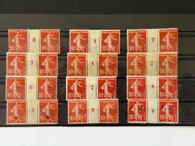 Plusieurs timbres de tailles et de couleurs différentes sont exposés dans une vitrine.