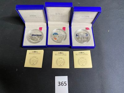 three silver coins are in a blue box with a price tag