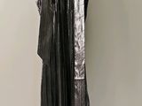 a black dress hanging on a hanger on a wall