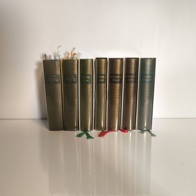 plusieurs livres sont alignés sur une surface blanche