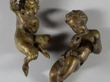paire de figurines anciennes en bronze représentant des chérubins sur fond blanc