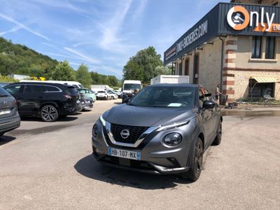 une voiture garée devant un immeuble sur lequel est accrochée une pancarte
