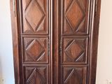 a wooden armoire with two doors on top of it