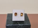 a pair of earrings sitting on top of a marble block