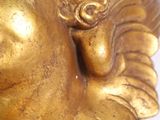 a gold statue of a woman with a bird on her head