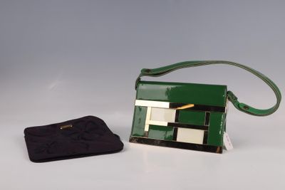 un sac à main vert et un sac à main noir posés sur une table blanche