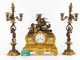 a clock that is sitting next to three candles