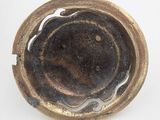 a close up of a metal bowl on a white surface