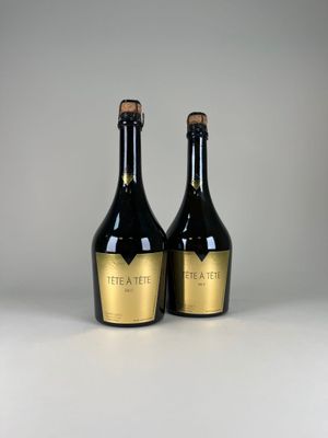 deux bouteilles de vin noir et doré posées sur une table
