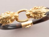a close up of a bracelet with two lions on it