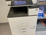 a printer that is sitting on the floor in front of a cabinet