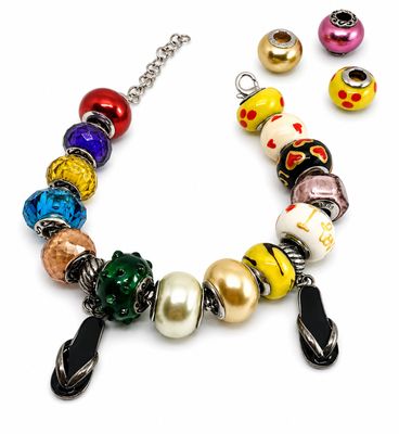 Ensemble composé d'un bracelet et de boucles d'oreilles en perles multicolores sur fond blanc