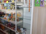 a refrigerator in the middle of a store filled with food