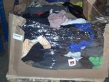 un tas de vêtements dans un carton, dans un entrepôt