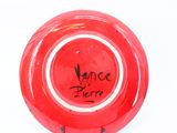 a red plate with writing on it on a white surface
