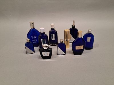 de nombreux flacons de parfum de différentes sortes posés sur une surface blanche