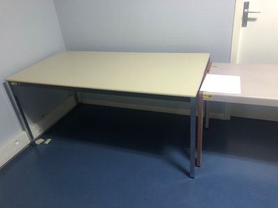un bureau au plateau blanc dans une petite pièce