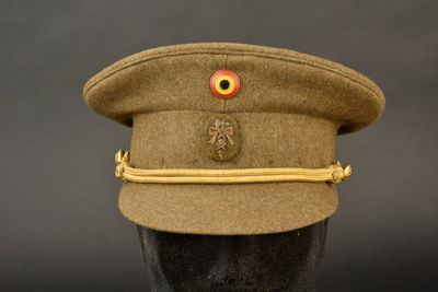 un chapeau orné d'un œil rouge, posé sur une tête de mannequin