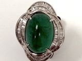 bague en argent sertie d'une pierre verte entourée de diamants taille baguette
