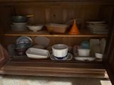 a cabinet with many dishes and bowls on it
