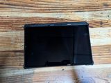 a small black tablet computer on a wooden table