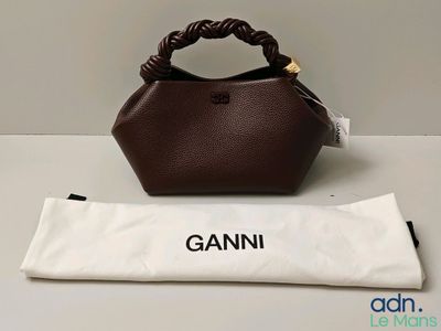 un sac marron posé sur une table, à côté d'un sac blanc