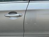 a silver car with a hole in the door handle