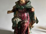 une figurine de femme assise sur une chaise