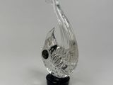 a clear glass fish sculpture sitting on top of a black base
