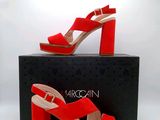Les chaussures rouges se trouvent sur la boîte à côté de la boîte noire.