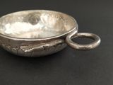 a close up of a silver bowl on a black surface