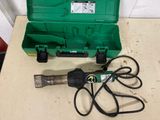 a green tool box with a green handle and a pair of scissors