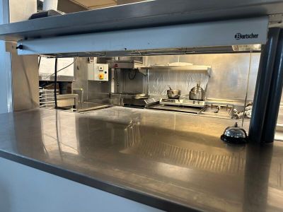 plan de travail en acier inoxydable dans une cuisine commerciale équipée d'appareils en acier inoxydable