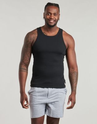 a man in a black tank top and grey shorts posing for a picture