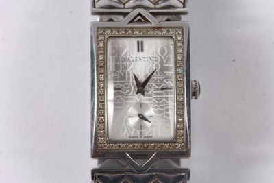 une image d'un gros plan d'une montre-bracelet sur une surface blanche