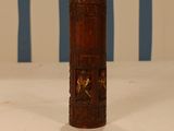 an old wooden cylinder with carvings on it sitting on a table