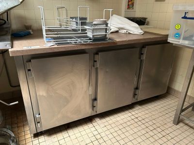 a kitchen with a sink and a counter with a lot of pots and pans on it