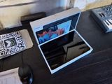 un ordinateur portable posé sur un bureau, avec un clavier à côté
