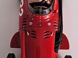 a red race car with a man in the driver ' s seat