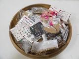 a wooden bowl filled with assorted jewelry and other items