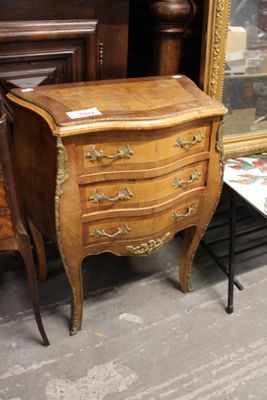 une petite commode en bois posée à côté d'une table