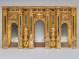 une sculpture en or représentant un homme et une femme devant un miroir