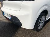 the rear end of a white car parked in a parking lot