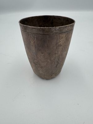 an image of a metal cup sitting on top of a white table