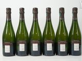 six bouteilles de vin sont alignées sur une surface blanche