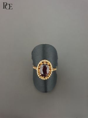 Gros plan sur une bague contenant une pierre rouge