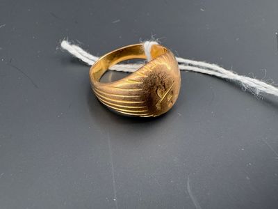 une bague en or suspendue à un fil sur une surface noire