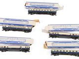 six wagons bleus et blancs sont alignés sur une surface blanche