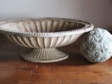 a bowl and two balls sitting on a wooden table